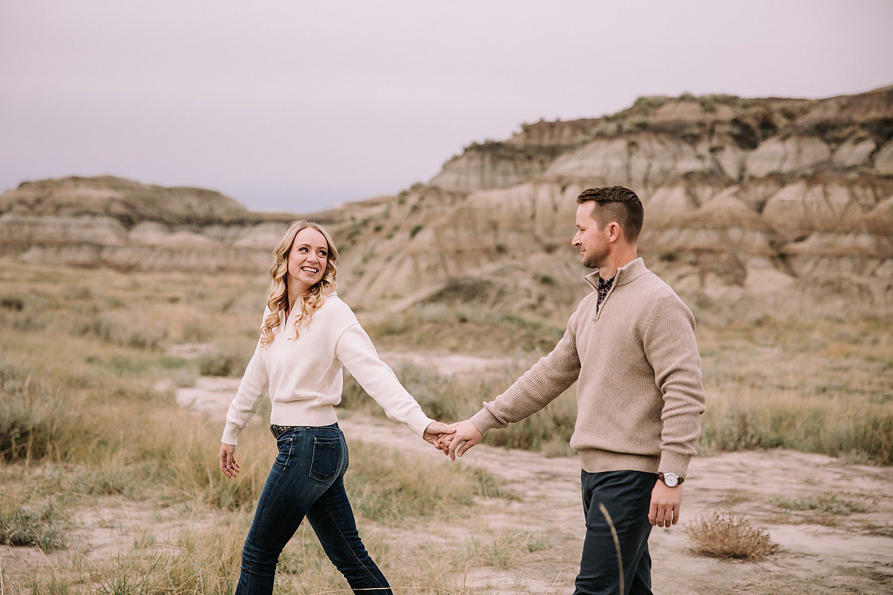 woman wearing jeans and a sweater looking back over her shoulder and smiling at her boyfriend who is always wearing jeans and a sweater