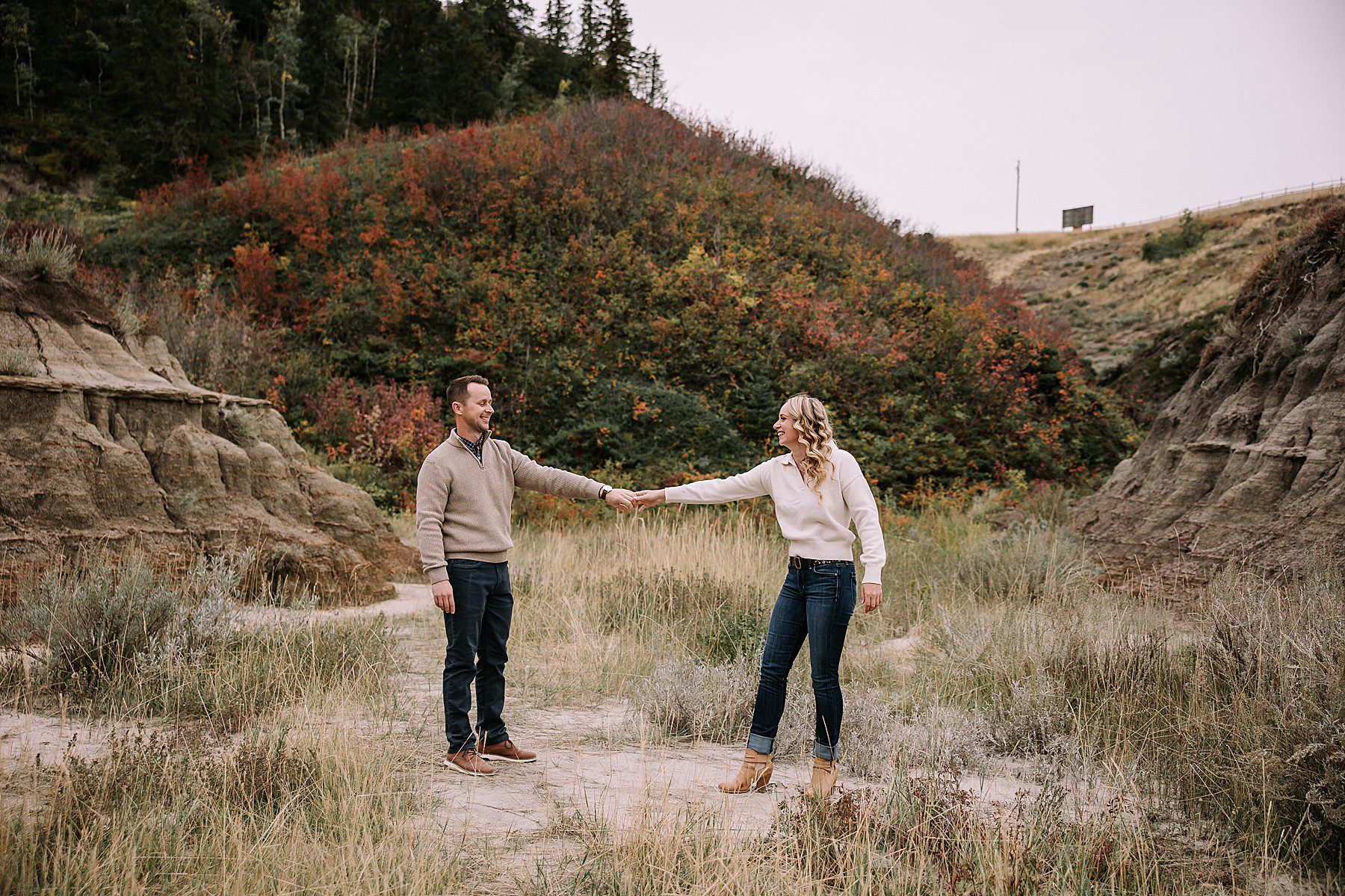 a happy couple smiling at each other while dancing in front of the hoodoos