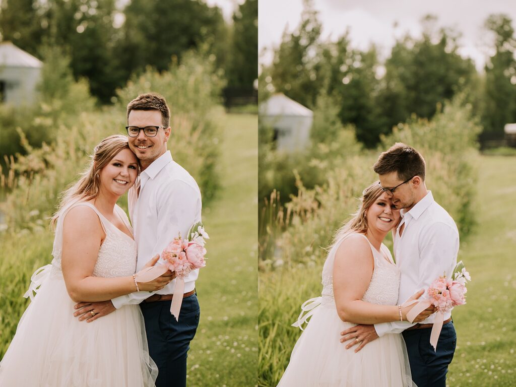 bride and groom standing in nature and snuggling close while posing for wedding photos. 
