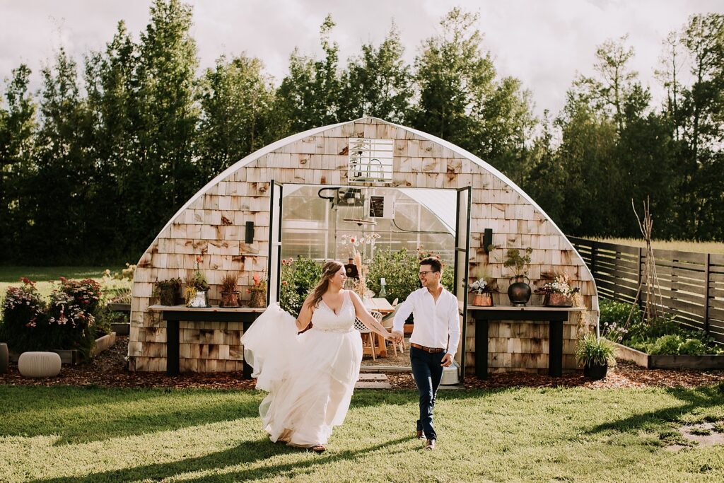 bride and groom standing in nature and snuggling close while posing for wedding photos. 