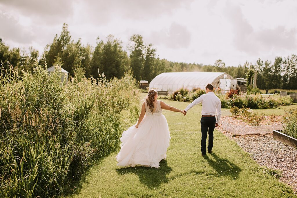 bride and groom standing in nature and snuggling close while posing for wedding photos. 